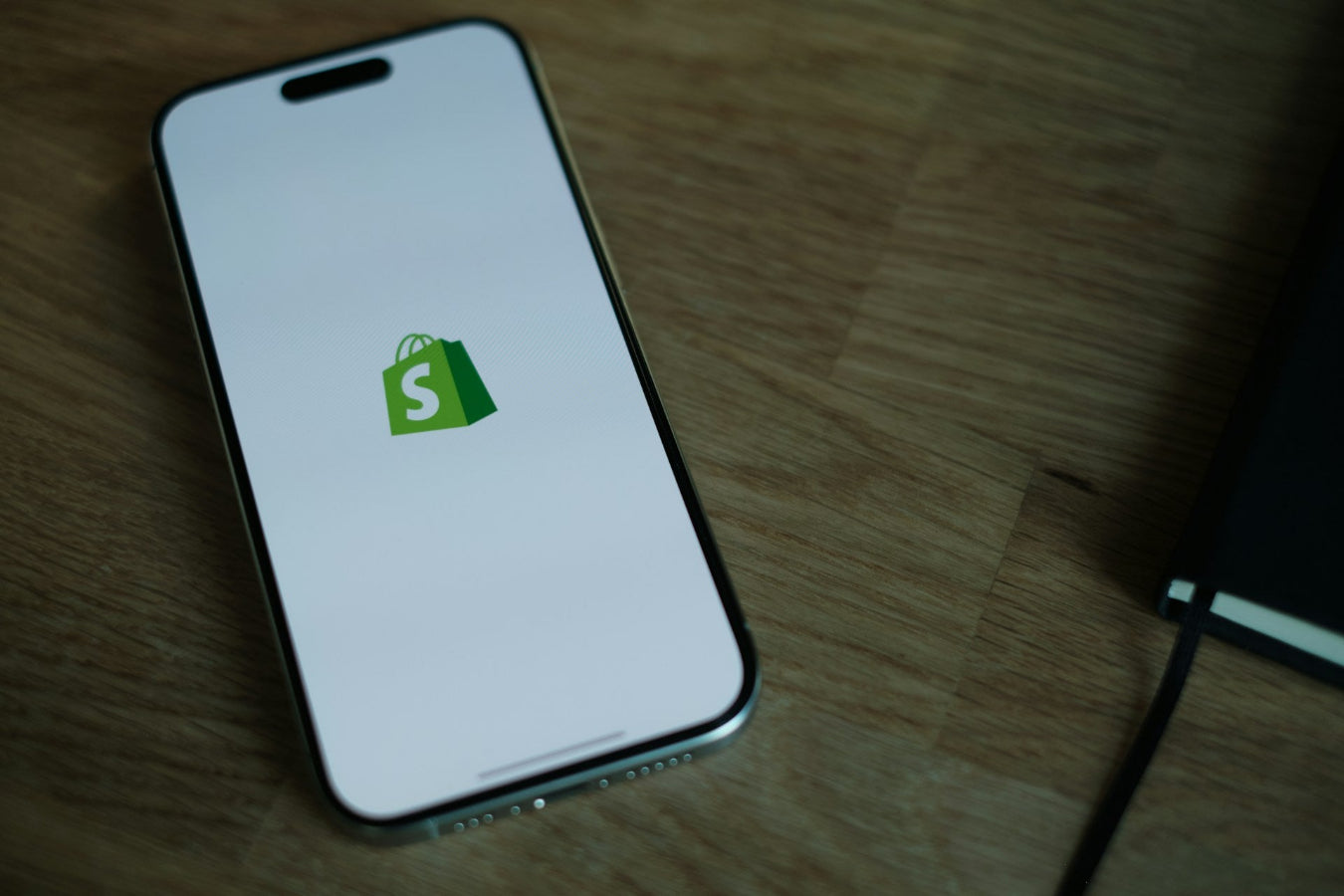 A phone showing the Shopify logo