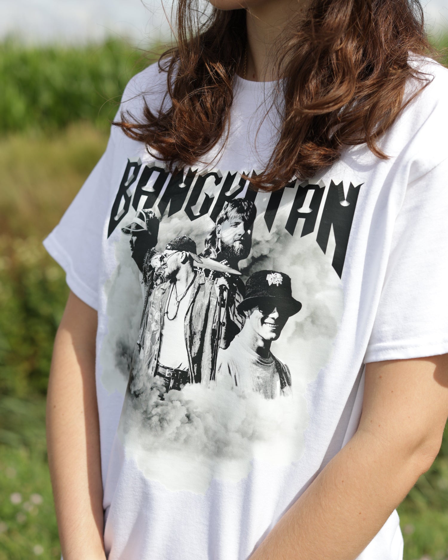 Person wearing a white BANGKITAN  t-shirt with black graphic design and text.