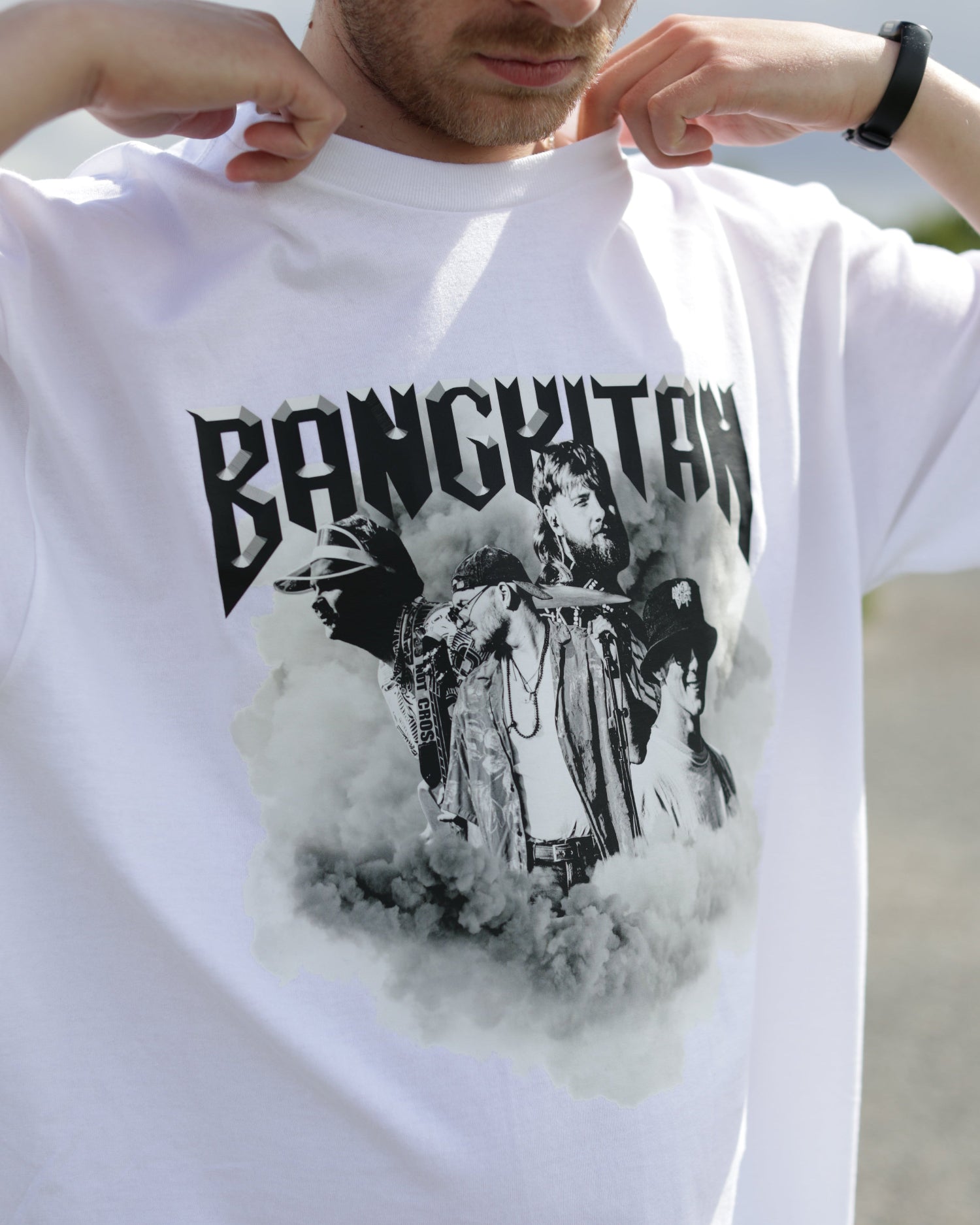 Person wearing a white BANGKITAN t-shirt with black graphic design and text.