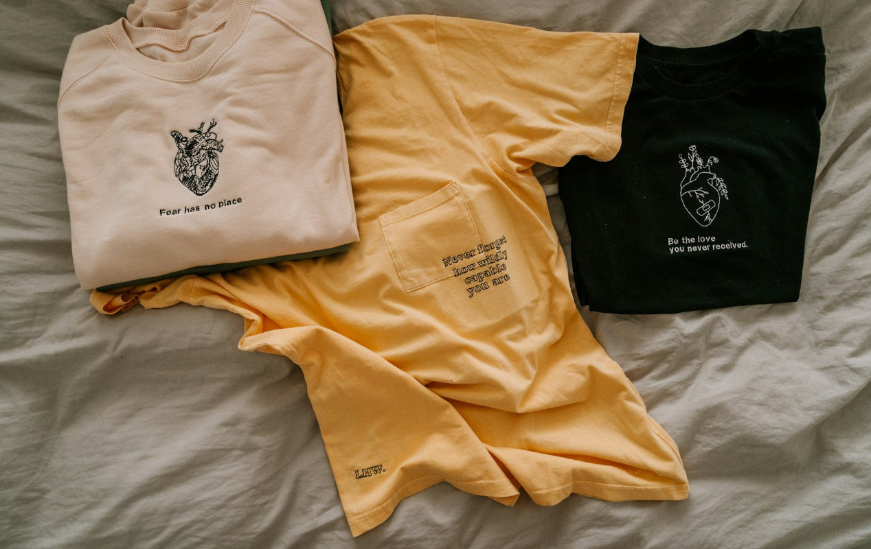 Three t-shirts folded on piece of fabric